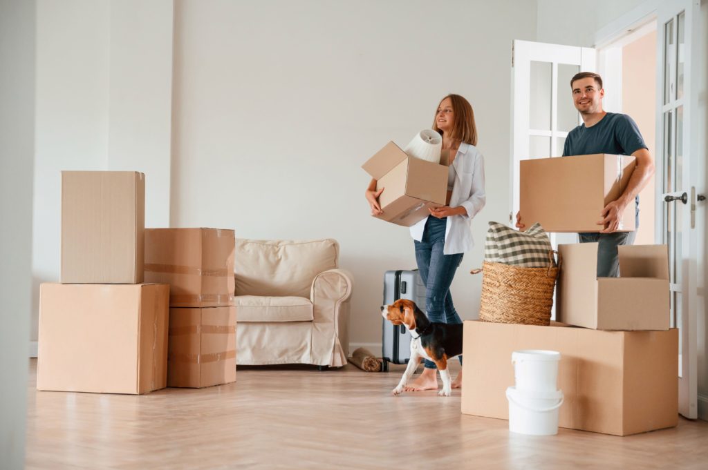 A couple and a dog moving into a new house
